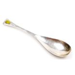 An Edward VII silver spoon of Arts & Crafts design, with an elongated bowl and yellow stone inset to