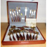 A canteen of Thai bronze cutlery, with wooden handles, in a fitted case.
