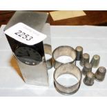 Two silver napkin rings, various thimbles, to include some silver examples, and a desk clock, with R