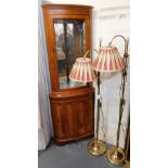 Two brass standard lamps, 151cm and 149cm high, and a yew standing corner cabinet.