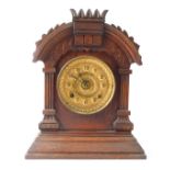 A late 20thC mahogany mantel clock, the arched pediment top on column supports, with a brass numeric