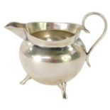 A Victorian Mappin & Webb silver milk jug, of plain cauldron design on tripod base, Sheffield 1896,