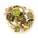 An abstract dress ring, with leaf and rose detail, set with peridot and citrine, yellow metal unmark