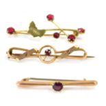 Three bar brooches, comprising two Victorian yellow metal bar brooches, stamped 9ct set with garnets