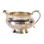 A silver milk jug, with acanthus leaf scroll handle and fluted border, on baluster stem, Birmingham