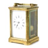 A French 20thC brass carriage timepiece, with white enamel Roman numeric dial, in a brass case, with