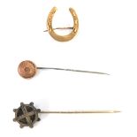 A group of jewellery, comprising a 9ct gold stick pin, a 9ct gold horseshoe brooch and a silver sti