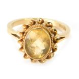 A 9ct gold citrine dress ring, the oval citrine in a rub over setting with rope twist border, and fl