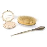 Three items of silver, comprising a silver handled hair brush, a silver octagonal compact, and a sil