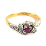 An 18ct cross over dress ring, centred by a pink stone, flanked two small white stones, with further