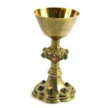 A Victorian silver gilt miniature chalice, with plain bowl elaborate stem inset with jewels, on a je