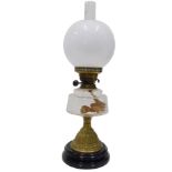 An early 20thC oil lamp, with brass mounts, plain glass reservoir, bell shaped stem and milk glass s