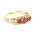 A 9ct gold three stone dress ring, set with purple stones on a fancy setting, size I, 1.8g all in.