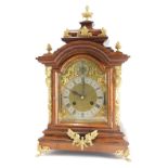 A late 19th/early 20thC rosewood cased mantel clock, with gilt metal mount, the arched dial with sub
