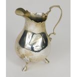 A Victorian silver jug, with shaped rim, ear handle, bulbous body and acanthus capped stepped hoof f