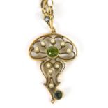 An Edwardian drop pendant, set with pearls, centred by a green stone in a floral surround with furth