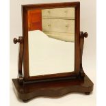 A Victorian mahogany swing frame mirror, rectangular plate, with shaped supports and serpentine fron