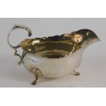 A George V silver sauce boat, with flying S scroll handle, acanthus capped triple hoof feet, Chester