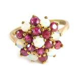 A dress ring set with opals and pink stones in a floral setting, on a part pierced shank marked 375,