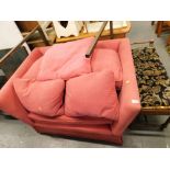 A red upholstered wide arm chair or small sofa. 122cm wide The upholstery in this lot does not compl