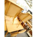 An unusual modern Lloyd Loom dining table on cluster column legs and four chairs, 2 with arms.