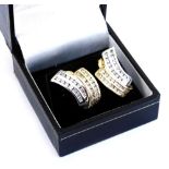 A pair of diamond earrings, each channel set with four rows of diamonds, in yellow and white metal,