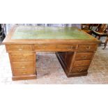 An early 20thC mahogany pedestal desk, the top with a green leather inset above an arrangement of ni