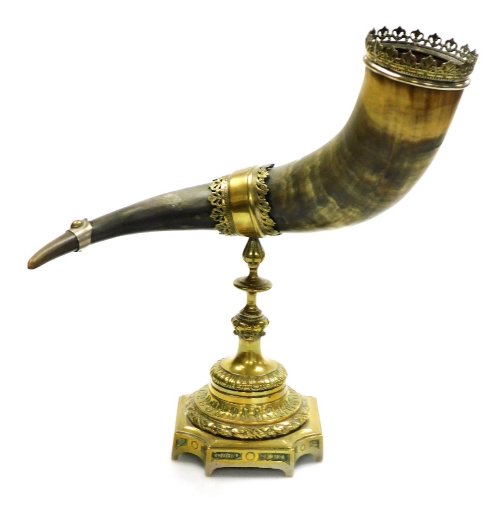 A 19thC cattle horn centrepiece, with a pierced brass crown mount, on a brass stand, 38cm high, 33cm