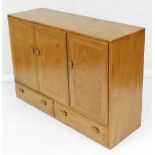An Ercol elm sideboard, with three cabinets above two drawers, 89cm high, 129cm wide, 43cm deep.