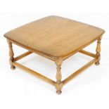 An Ercol elm coffee table, the rounded, square top raised on baluster turned supports, united by a b