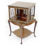 A Edwardian mahogany revolving bookcase, the square top with a moulded edge above four fret work div