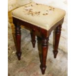 A Victorian mahogany stool, with a later woolwork padded seat, on turned tapering legs.
