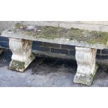 A composition garden bench, rectangular top above two scroll decorated ends, 39cm high, 100cm wide,