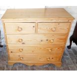 A pine chest of drawers, the top with a moulded edge above two short and three long drawers, raised