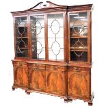 A Charles Barr Georgian style mahogany breakfront bookcase, the swan neck pediment with dentil mould