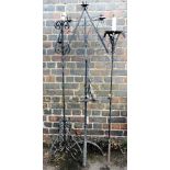 A group of painted wrought metal standard lamps and candle holders, and a four branch light fitting.
