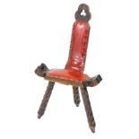 A Continental stained pine spinning chair, with red leatherette padded seat on three legs.