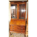 An Edwardian mahogany and ebony strung bureau bookcase, the outswept pediment top above two astragal