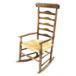 A late Victorian Clisset type rocking chair, with a rattan seat, on turned supports.