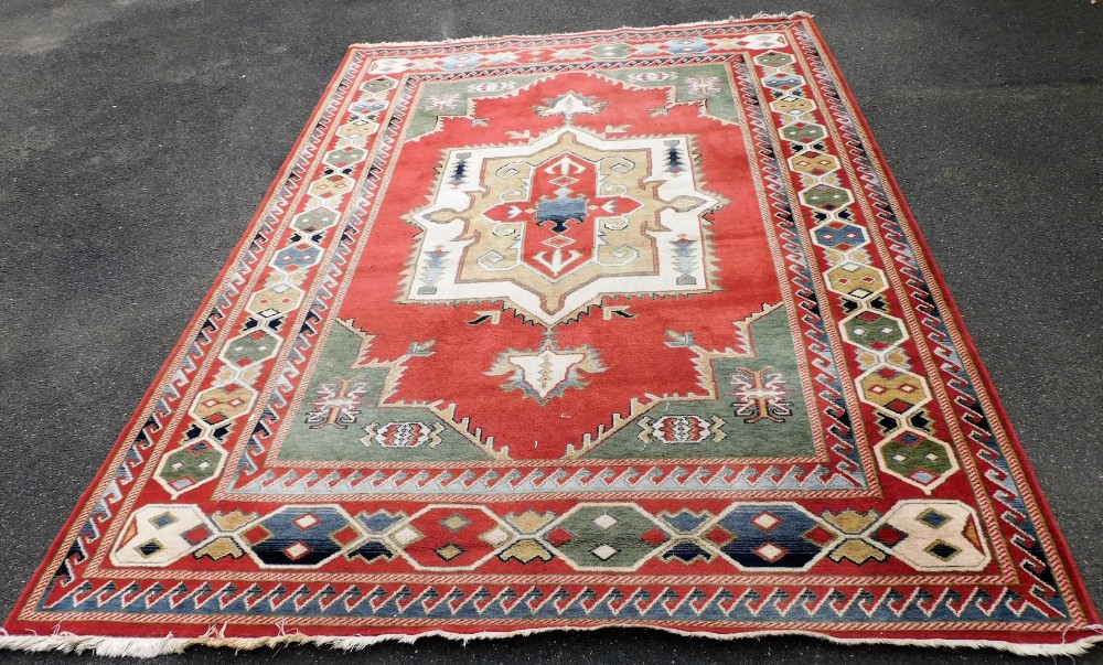 A Caucasian wool rug, decorated with medallions and multiple borders, 340cm x 245cm.