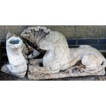 A composition garden statue of a recumbent lion, 73cm wide, and a bird bath, with a shell shaped top