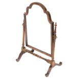 An Edwardian mahogany swing frame toilet mirror, with an arched plate, on turned supports with splay