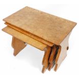 A nest of three Thomas Whittaker Gnomeman oak tables, each of rectangular form, on trestle type supp