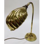 A brass effect desk lamp, with shell shaped shade, adjustable column and domed foot, 75cm high.