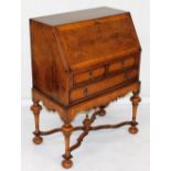 A Georgian style walnut bureau, the feather banded quarter veneered fall enclosing a fitted interior