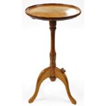 A Bob Hunter Wrenman oak wine table, the circular top raised on a slender, leaf carved, baluster col