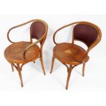 A pair of early 20thC bentwood armchairs, each with a maroon leatherette and brass buttoned padded b