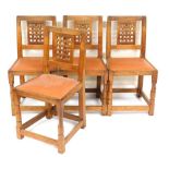 A set of four Robert Thompson Mouseman oak dining chairs, with a lattice back and leather studded se