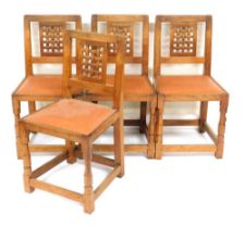 A set of four Robert Thompson Mouseman oak dining chairs, with a lattice back and leather studded se