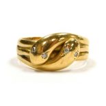 An 18ct gold ring of double serpent form, each serpent's head inset with diamond eyes, approximately
